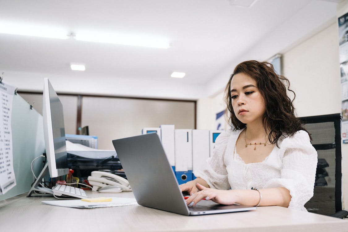 Free Woman in White Lace Top Using Laptop Stock Photo