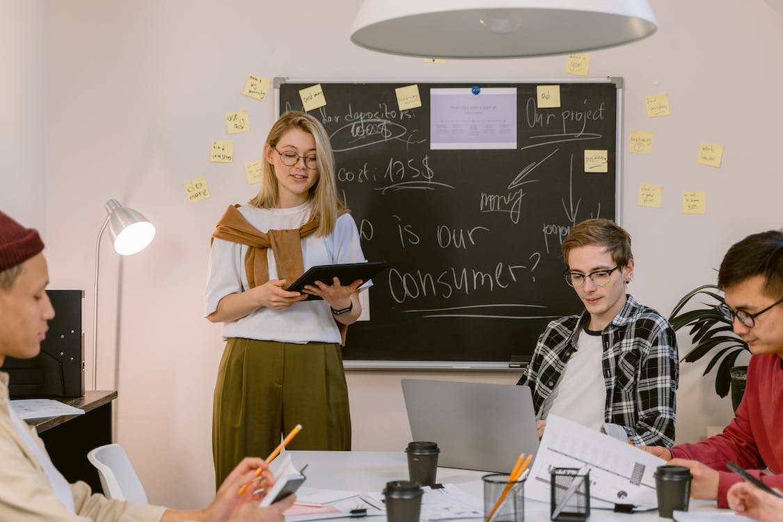 Free Woman in White Shirt Presenting at the Meeting Stock Photo